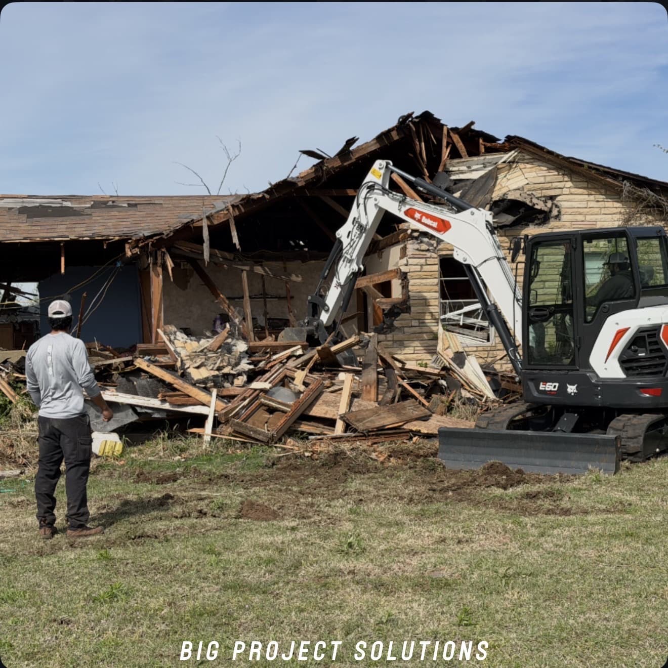 CAT excavator working a concrete debris pile after a demolition in the Oklahoma City metro