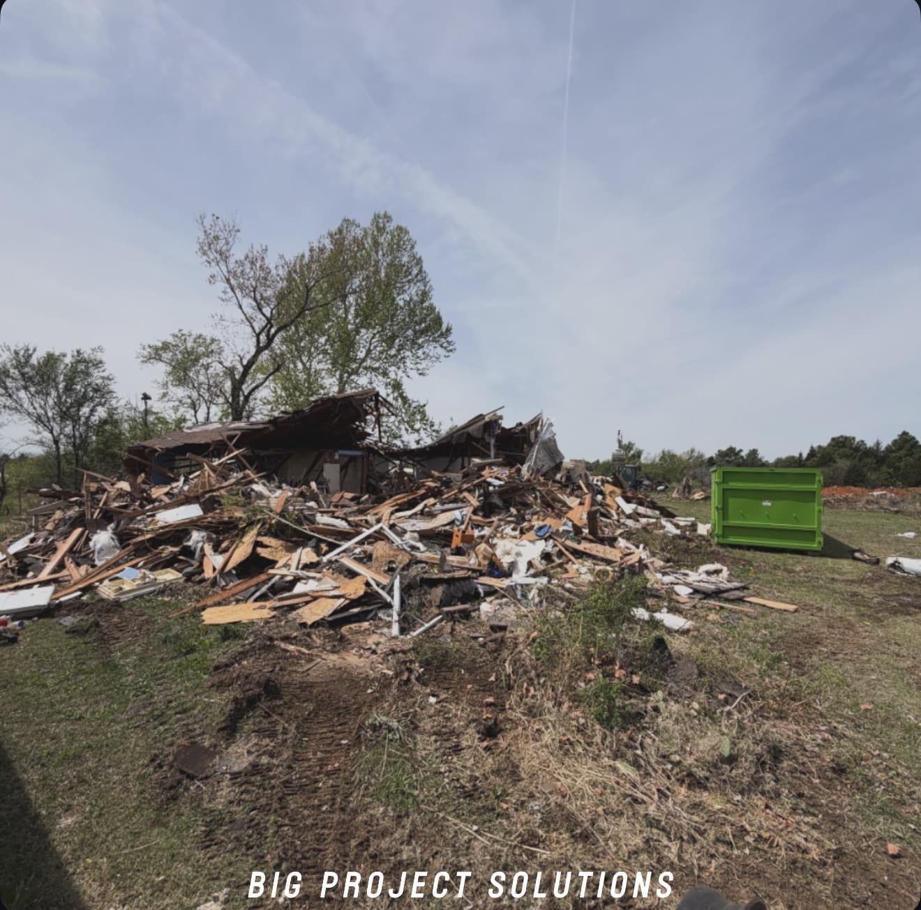 Old house before demolition with a Bobcat and roll-off containers staged on site in the Oklahoma City metro