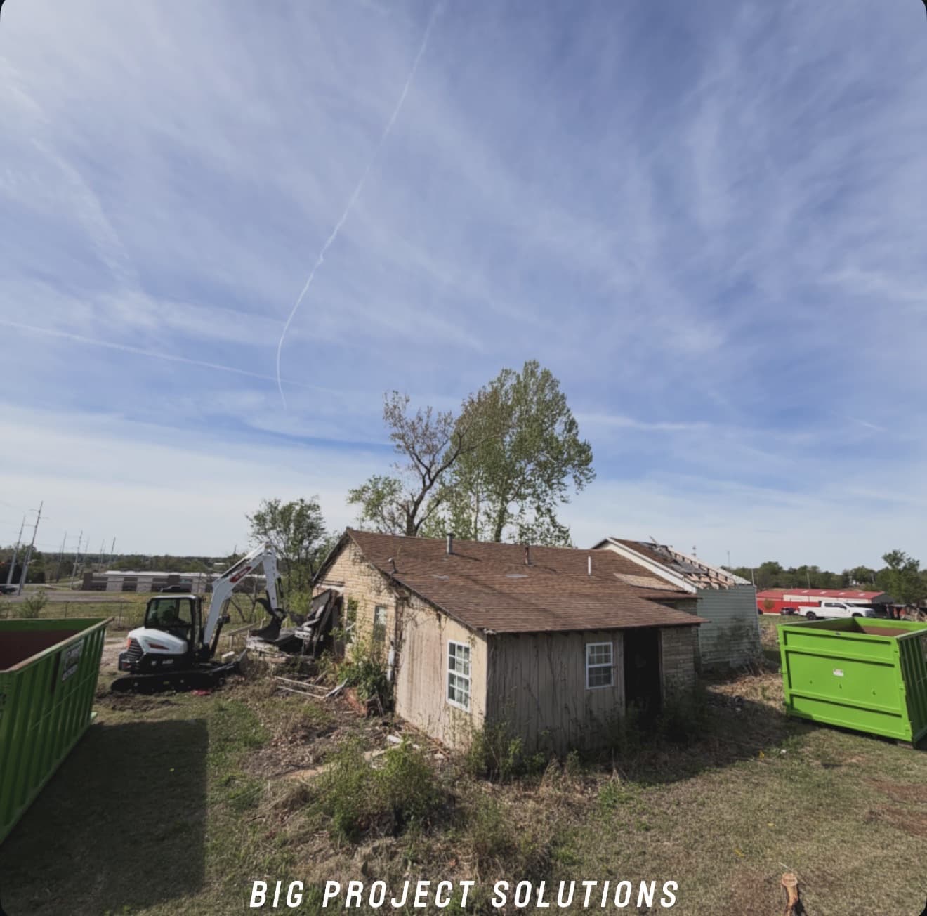 Cleared lot with roll-off containers on site after a teardown in the Oklahoma City metro